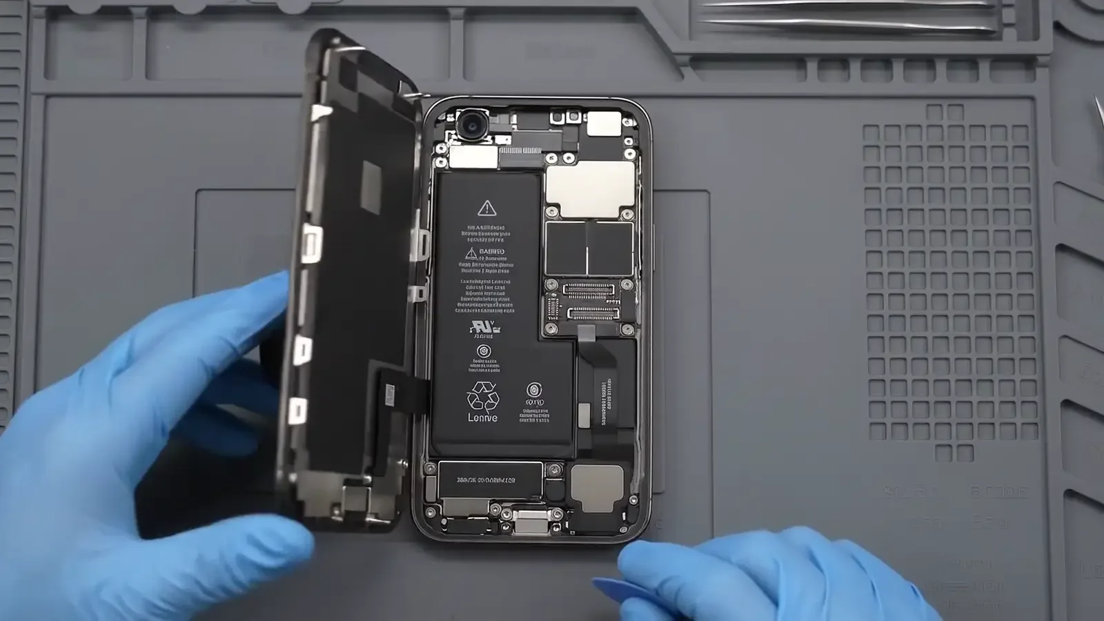 Placa interna de iPhone aberta na bancada